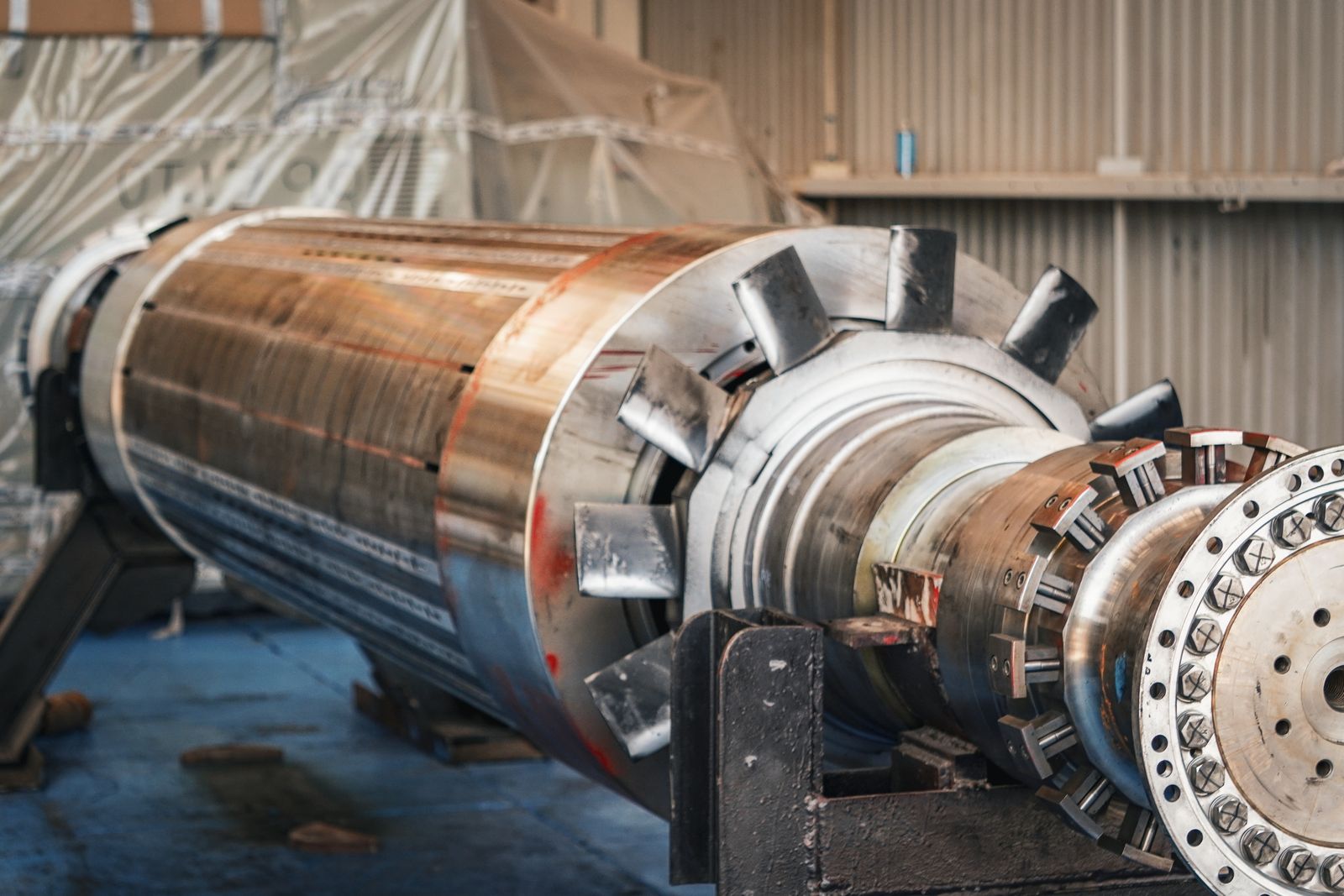 Large industrial rotor component resting in a workshop before installation.